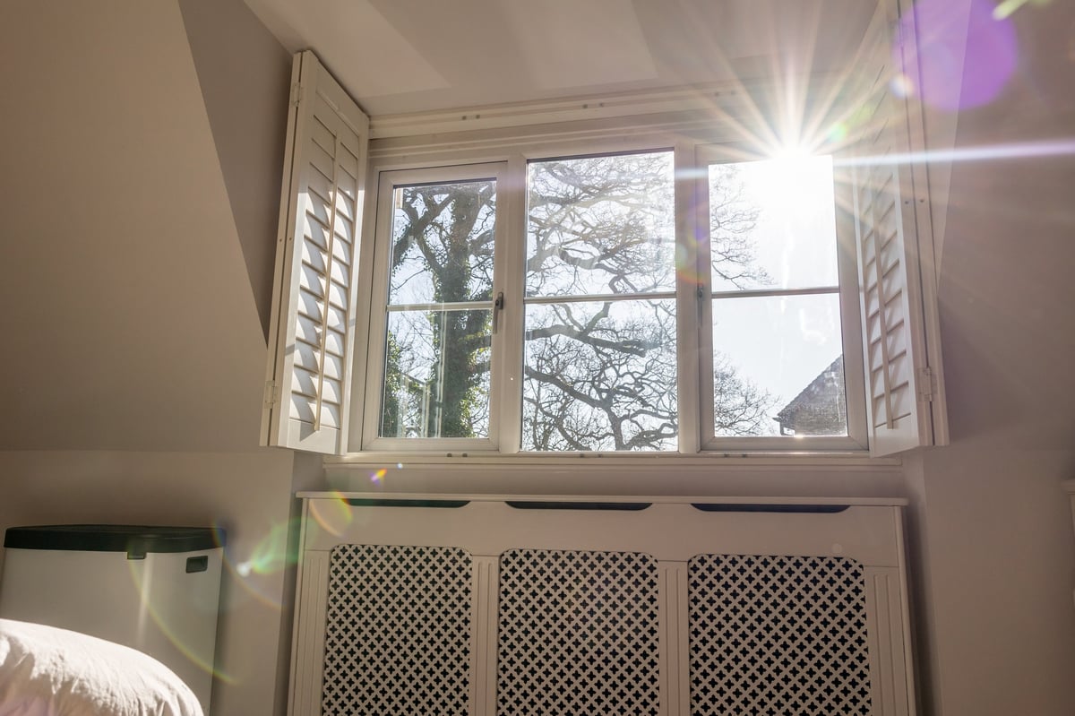 Sunlight falling through a tall residential window into a quiet, empty room