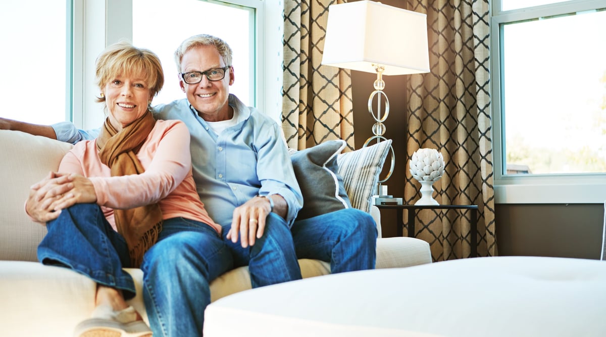 A senior couple relaxing together on the sofa in their living room